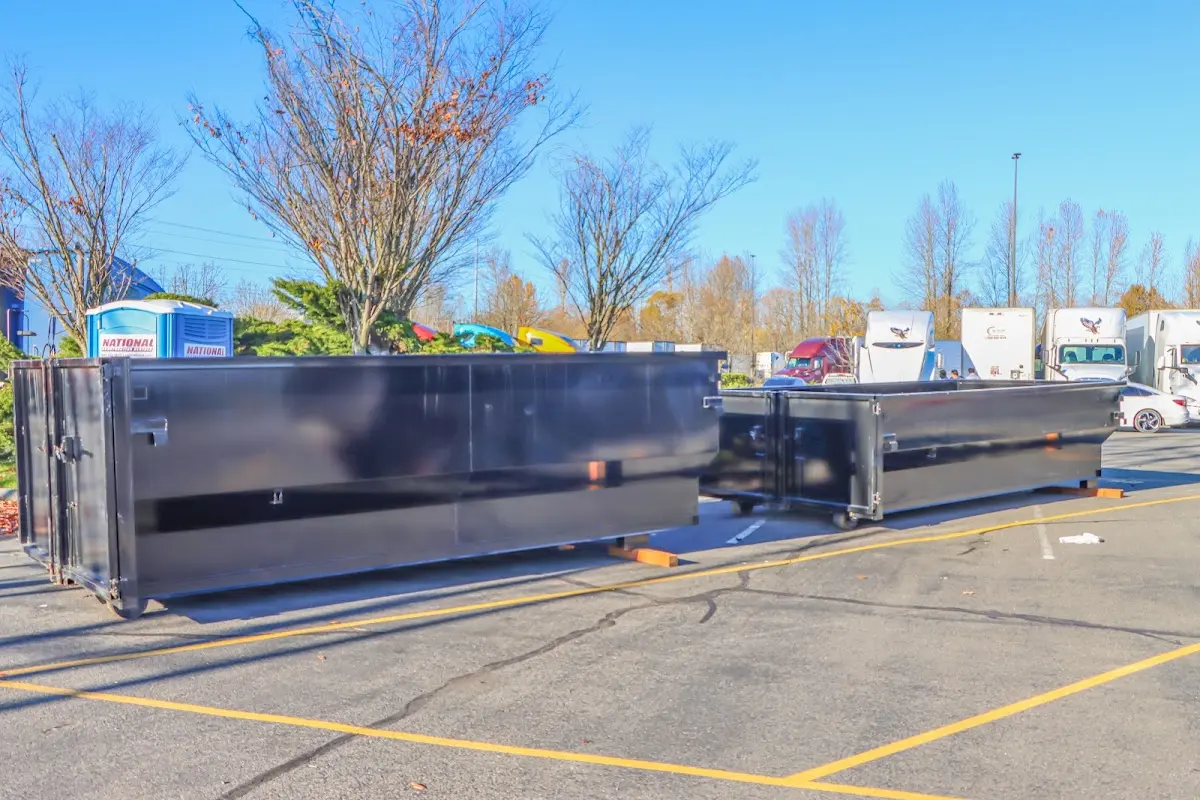 Professional dumpster rental service with roll-off container on residential driveway in Penfield